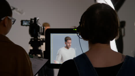 Female-Film-Director-And-Assistant-Watching-Actor-On-Monitor-Shooting-Movie-Or-Video-Scene-In-Studio-Shot-In-Real-Time-1